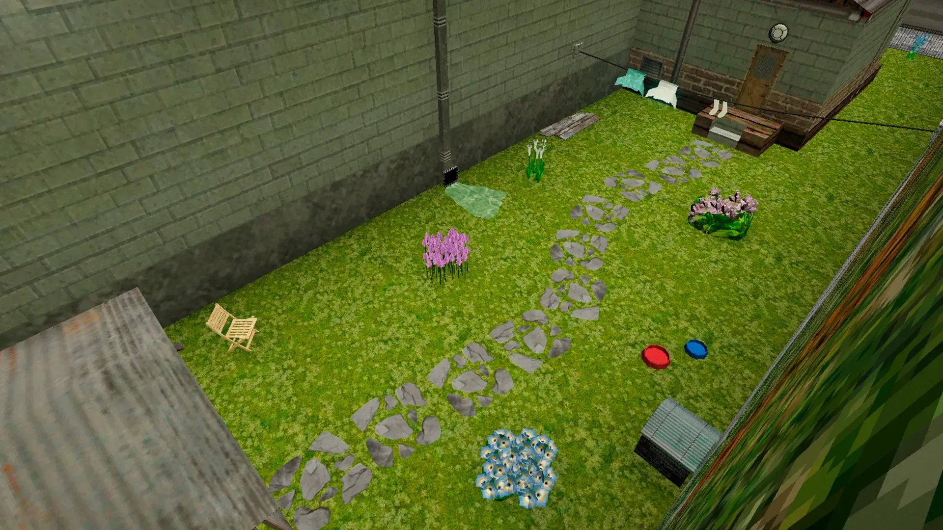The garden in spring from above: a stone path across the grass, flower beds and two pet bowls